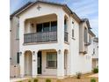 A beautiful two-story townhome featuring stucco exterior, black trim, and a balcony overlooking the front yard at 4063 E Amoroso Dr, Gilbert, AZ 85296