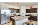 Modern kitchen with stainless steel appliances, granite countertops, and a large island with seating at 4080 N 309Th Cir, Buckeye, AZ 85396