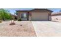 Inviting home featuring a two-car garage, desert landscaping, and a cozy, welcoming facade at 42347 W Bunker Dr, Maricopa, AZ 85138