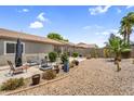 Spacious backyard with desert landscaping, a covered patio, and plenty of room for outdoor activities at 43787 W Colby Dr, Maricopa, AZ 85138