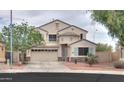 Charming two-story home featuring a three-car garage and desert landscaping at 44890 W Desert Garden Rd, Maricopa, AZ 85139