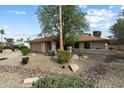 A well kept front yard with desert landscaping and mature trees leading to a single story home and two car garage at 6725 E Kings Ave, Scottsdale, AZ 85254