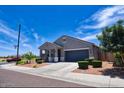 Well-manicured lawn and tidy landscaping complement this cozy single-level home with an attached garage at 7751 W Miami St, Phoenix, AZ 85043
