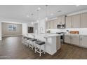 Bright kitchen featuring stainless steel appliances, a large island, stylish pendant lights and wood floors at 11334 S 52Nd Ln, Laveen, AZ 85339