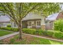 Attractive home featuring a charming porch, mature tree, and manicured landscaping at 1143 S Annie Ln, Gilbert, AZ 85296