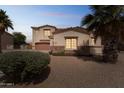 Home featuring desert landscaping, a stone facade, and mature palm trees in the front yard at 120 N Pottebaum Rd, Casa Grande, AZ 85122