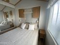 Well-lit bedroom with a queen bed, a large mirror, and built-in cabinets providing ample storage at 1226 S Seneca Dr, Apache Junction, AZ 85119