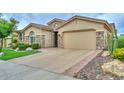 Single-story home featuring a stone facade, well-manicured lawn, and a long driveway at 13353 W Gloria Ln, Peoria, AZ 85383
