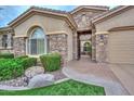 Inviting single-story home with stone accents, manicured lawn, and gated entryway at 13353 W Gloria Ln, Peoria, AZ 85383