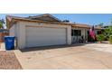 Home's front exterior featuring a two-car garage, wide driveway and desert landscaping at 13614 N 33Rd Ave, Phoenix, AZ 85029