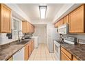 Efficient kitchen featuring modern white appliances and ample cabinet space and tile flooring at 13614 N 33Rd Ave, Phoenix, AZ 85029