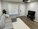 Living room showcasing a gray sectional sofa, television set, and a bright window at 1449 E Highland Ave # 25, Phoenix, AZ 85014