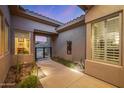 Charming courtyard entrance with desert landscaping, pavers, and architectural details, leading to a welcoming home environment at 14523 E Charter Oak Dr, Scottsdale, AZ 85259