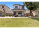 Charming two-story home features a well-manicured lawn and inviting front porch with stylish brick accents at 1563 S Longspur Ln, Gilbert, AZ 85296