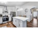 Bright kitchen featuring white cabinets, stainless steel appliances, pendant lighting, and an island with seating at 15743 N 165Th Ln, Surprise, AZ 85388