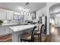 Bright kitchen featuring white cabinets, stainless steel appliances, pendant lighting, and an island with seating at 15743 N 165Th Ln, Surprise, AZ 85388