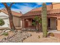 View of the house entrance with desert landscaping and a decorative cactus in the front yard at 16017 S 12Th Pl, Phoenix, AZ 85048