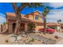 Charming two-story home featuring desert landscaping, a red car, and a covered front porch area at 16017 S 12Th Pl, Phoenix, AZ 85048