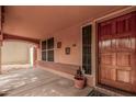 Covered front porch area featuring textured walls, a window, and a view to the side yard at 16017 S 12Th Pl, Phoenix, AZ 85048