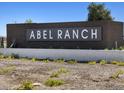 Stone sign at Abel Ranch community entrance with desert landscaping featuring flowering plants at 17643 W Mariposa Dr, Goodyear, AZ 85395