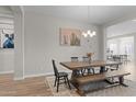 Dining room with a wooden table, bench, and chandelier; seamlessly connects to kitchen and other living areas at 21132 W Windsor Ave, Buckeye, AZ 85396