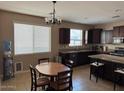 Open kitchen featuring dark wood cabinets, granite countertops, and a dining area at 21544 W Watkins St, Buckeye, AZ 85326