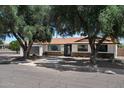 Charming single-story home with stone accents, mature trees, and a well-maintained front yard at 2802 E Mercer Ln, Phoenix, AZ 85028