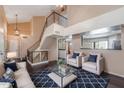 Bright, airy living room with high ceilings, a staircase, and a view of the kitchen at 4114 E Muirwood Dr, Phoenix, AZ 85048