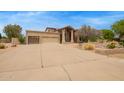 Wide driveway leading to a house with a three-car garage and well-kept landscaping at 4922 W Fallen Leaf Ln, Glendale, AZ 85310
