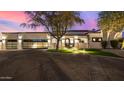 Beautiful exterior view of home at dusk with manicured lawn, desert landscaping, and gated garages illuminated by exterior lights at 5404 N 41St St, Phoenix, AZ 85018