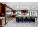 Modern kitchen with stainless steel appliances, large island, granite countertops, and pendant lighting at 5404 N 41St St, Phoenix, AZ 85018