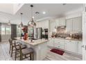 Bright kitchen featuring an island with barstool seating, stainless steel appliances, and modern pendant lighting at 5407 S Tatum Ln, Gilbert, AZ 85298