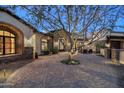 Inviting courtyard with a mature tree, stone accents, and a welcoming entrance to a desert home at 6102 E Sage Dr, Paradise Valley, AZ 85253