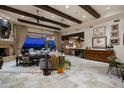 Spacious living area featuring exposed beams, a fireplace, and seamless indoor-outdoor flow with mountain views at 6102 E Sage Dr, Paradise Valley, AZ 85253