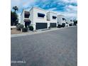 Street view of townhouses featuring private garages, manicured landscaping, and inviting curb appeal at 727 W Maryland Ave # 1, Phoenix, AZ 85013