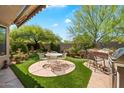 Outdoor living space with a built-in grill, seating, and lush landscaping at 7291 E Eagle Feather Rd, Scottsdale, AZ 85266