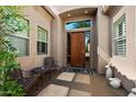 Inviting front porch with decorative chairs, a table, and elegant doorway at 7291 E Eagle Feather Rd, Scottsdale, AZ 85266