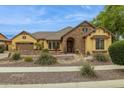 Beautiful exterior view showcasing desert landscaping, a stone accent wall, and tan stucco at 7587 W Quail Ave, Glendale, AZ 85308
