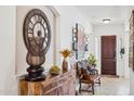 Inviting foyer with decoratively adorned console table and bench seating at 7587 W Quail Ave, Glendale, AZ 85308