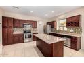 Spacious kitchen with tile flooring, an island, stainless appliances, and wood cabinets at 8214 S 48Th Dr, Laveen, AZ 85339