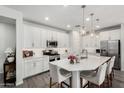 Modern kitchen with white cabinets, stainless steel appliances, and a large island at 9418 W Minnezona Ave, Phoenix, AZ 85037