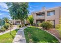 Beautifully landscaped exterior view of the apartment complex with lush green grass and mature trees at 11260 N 92Nd St # 2111, Scottsdale, AZ 85260