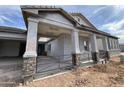 New construction home showing covered front porch with stone column accents and metal railing at 1171 E Peach Tree Dr, Chandler, AZ 85249