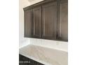 Kitchen featuring dark wood cabinets, white quartz countertops, and stainless steel hardware at 1171 E Peach Tree Dr, Chandler, AZ 85249