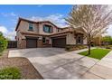 Exterior of home with three car garage, extensive driveway, and landscaped yard at 13367 W Jesse Red Dr, Peoria, AZ 85383