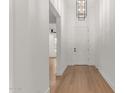 Bright foyer with hardwood floors, decorative lighting, and white front door at 13367 W Jesse Red Dr, Peoria, AZ 85383