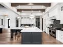 Spacious kitchen featuring a large island, wooden beams, stainless steel appliances, and white cabinetry at 13750 E Yucca St, Scottsdale, AZ 85259