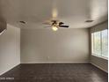Spacious living room featuring tile flooring, a ceiling fan, and large windows with natural light at 13921 W Port Royale Ln, Surprise, AZ 85379