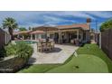 Entertainer's backyard with a swimming pool, covered patio, putting green and outdoor kitchen at 1461 W Tara Dr, Gilbert, AZ 85233