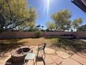 Large backyard with mature trees, a rock firepit and privacy wall at 14617 S 35Th Pl, Phoenix, AZ 85044